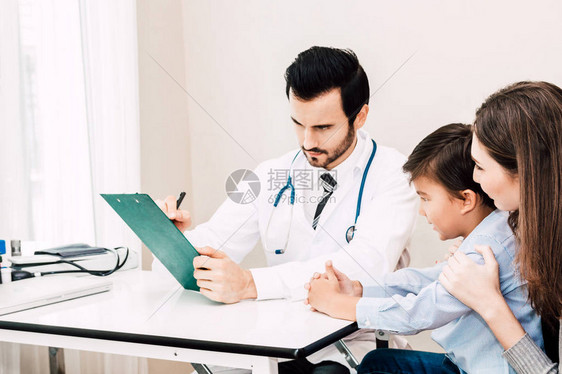医生在医院的医生桌上与小男孩和妈核对信息医图片