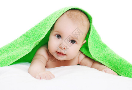 婴儿躺在绿色毛巾下的特写肖像图片