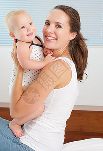 一个快乐的母亲抱着可爱笑的婴儿玩耍图片