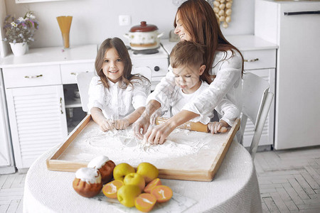 家庭在厨房里美丽的母亲有孩子白背景图片