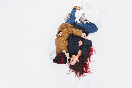 幸福的情侣躺在雪里笑着图片