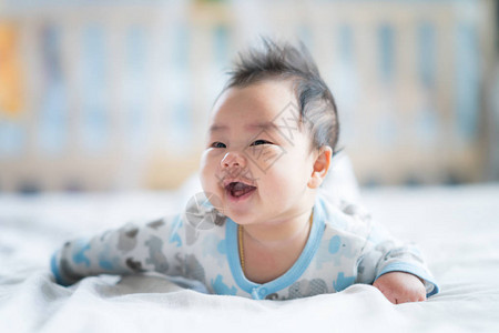 新生男孩在床上微笑婴儿新生儿图片