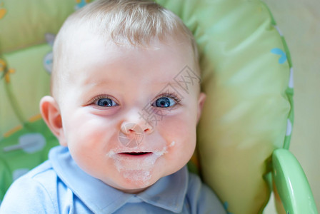 金发大蓝眼睛的可爱小宝肖像快乐无忧虑的童年孩子在吃牛奶和泥浆图片
