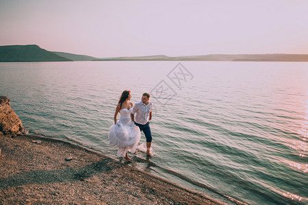 跑在海滩的愉快的浪漫夫妇图片