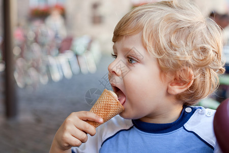 小蹒跚学步的男孩在夏天吃锥形冰淇淋图片