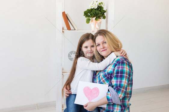 母亲节快乐小女儿祝贺妈并给了她明信片妈和小女孩微笑着拥图片