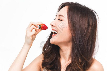 女人在白背景上吃新鲜草莓玩弄概念图片