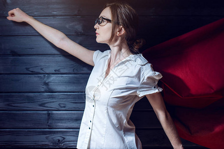 女超人有吸引力的女上班族站在西装和红色斗篷像一个超级英雄职图片