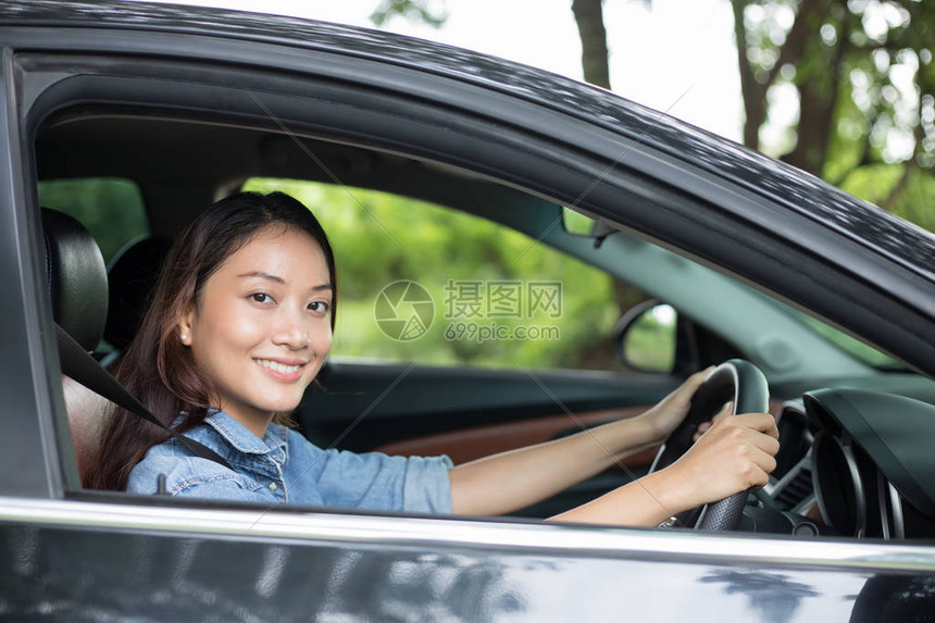 美丽的亚洲女在路上驾车旅行时笑图片