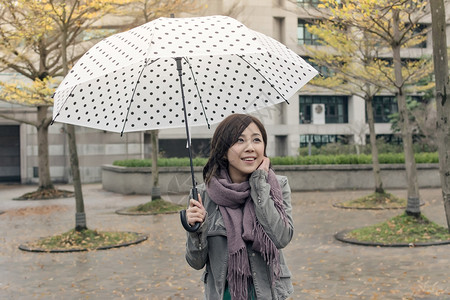 当雨停时在城市撑着伞露出笑容亚洲女士图片