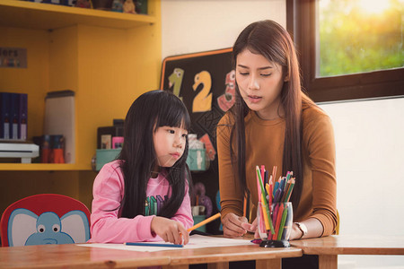 教师和学生在学前班图书馆母亲艺术学校教师教育和儿童概念中图片