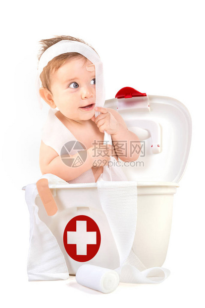 可爱的男婴在急救箱里玩绷带图片