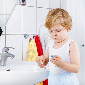 可爱的金发小男孩在家庭浴中学习刷牙孩子们学习图片