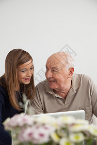 女孩帮助她的祖父用电脑图片
