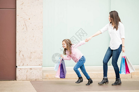 女儿拉着妈妈逛街购物图片