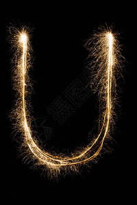 英文大字母U由黑色背景上的燃烧火花制成闪亮的节日派对烟花字体图片