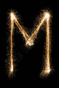 英文大字母M由黑色背景上的燃烧火花制成闪亮的节日派对烟花字体图片
