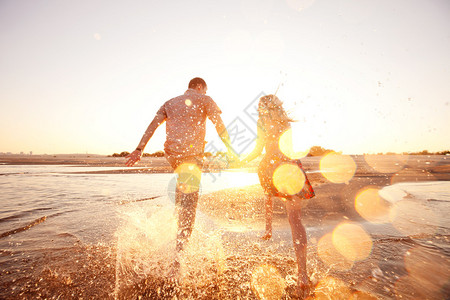 幸福的情侣在沙滩上奔跑图片