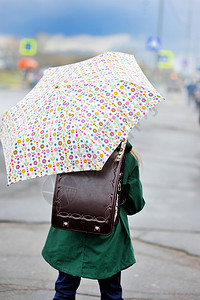 穿着多彩的雨天在市街上散步的伞子图片