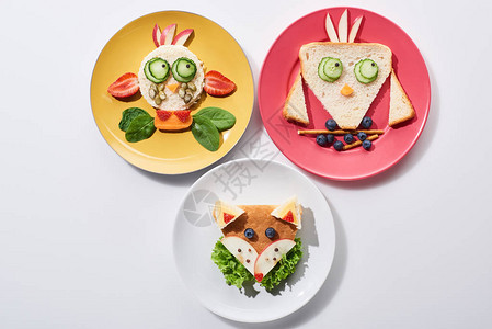 白色背景的儿童早餐用花式牛鸟和狐狸制成的盘图片