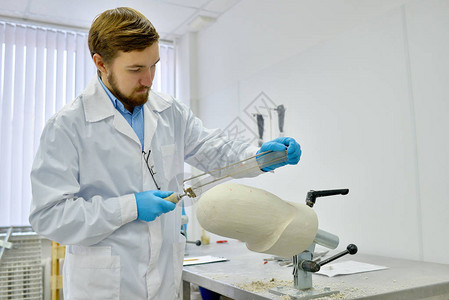 在现代设计实验室工作的青年假肢技术员的沙砂化假肢模图片