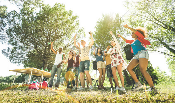 多种族朋友在烧烤野餐花园派对上玩得开心友谊多元文化概念与年轻快乐的人在春假营地喝酒跳舞阳光图片