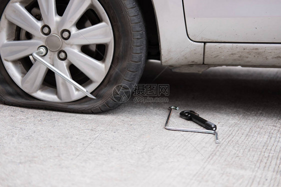 由于钉子敲击导致汽车轮胎泄漏路上轮胎瘪了压扁刺破的汽车轮图片