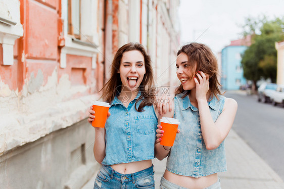美丽的女孩们在街上喝咖啡图片