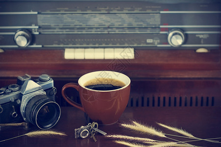 咖啡杯和相机胶片关于旧式无线电背图片
