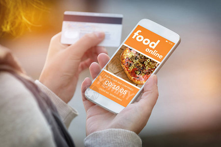 在线订购食物智能手机在手和信用卡在其他在办公室或工作场所订图片