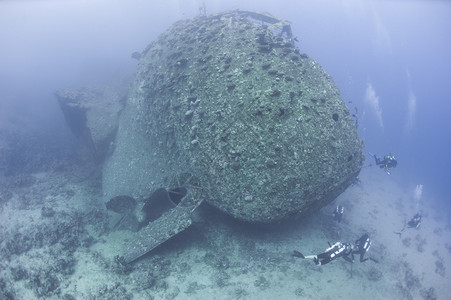 探索大型水下沉船的底部分的潜水员Sc图片