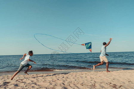 快乐的非洲父亲和儿子玩风筝图片