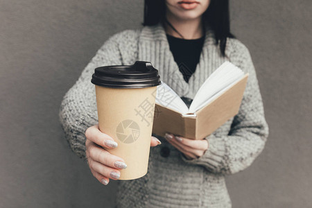 在毛衣阅读书和咖啡前的咖啡中图片
