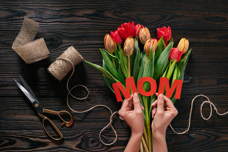 母亲与母亲在木桌顶上用手写字和花束的郁金香图片
