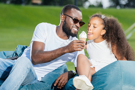 给女儿吃冰淇淋在公园的豆袋椅图片