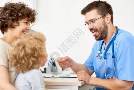 友好儿科医生在任职期间检查坐在母亲手臂上图片