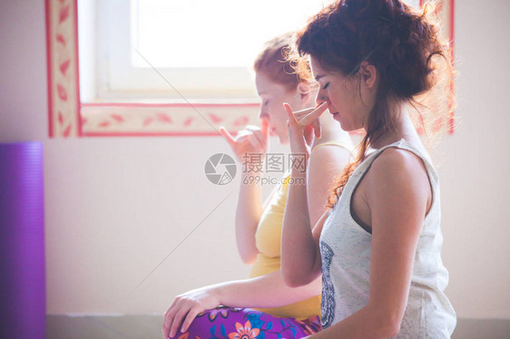 关闭参加瑜伽课锻炼的两名妇女图片