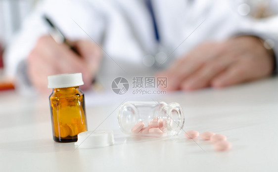 医生办公桌上装满药丸的瓶子图片