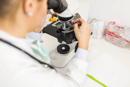 在实验室使用显微镜的女医生或女科学研究背景图片