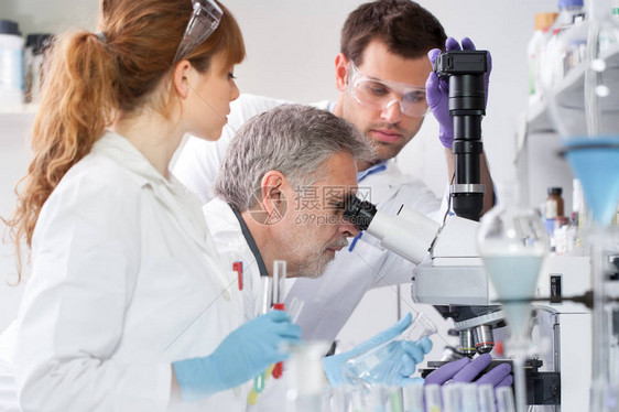 卫生保健研究人员在生命科学实验室进行显微镜检查年轻的研究科学家和高级教授在研究实验室准备和分析图片