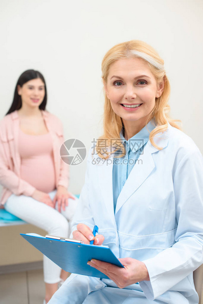 剪贴板和年轻孕妇的产科妇产科妇医生其图片