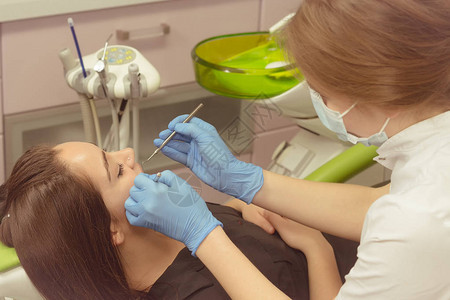 牙医在牙科诊所检查妇女的牙齿图片