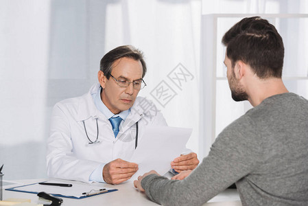 医生阅读男患者文件图片