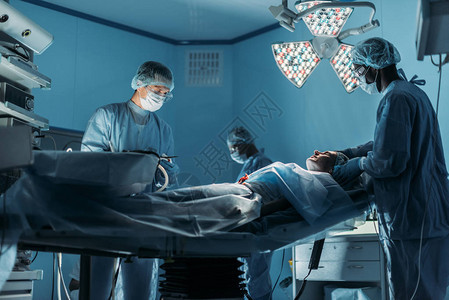 多文化医生为病人在手术室做手术图片