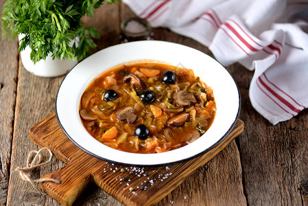 酸菜排骨俄罗斯传统汤solyanka由菜新鲜和干燥的蘑菇以及橄榄柠背景