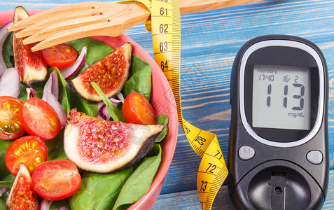 水果和蔬菜沙拉具有测量糖水平和卷尺结果的血糖仪糖尿病概念饮食减肥健康生背景图片