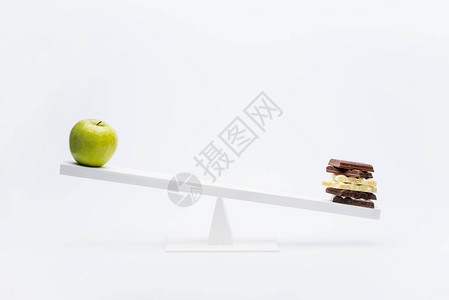 近距离观察苹果和巧克力在锯木上的平衡健图片