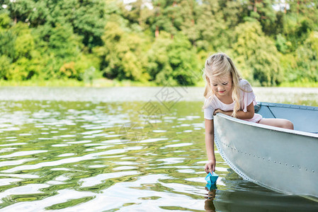 快乐的小孩在湖上漂浮在船上时发图片