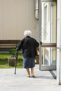 拄着拐杖走路的老妇人背景图片