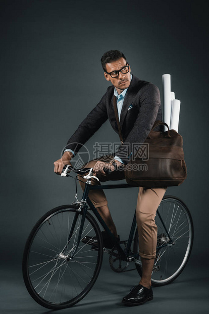 自信的商人骑着单车背图片